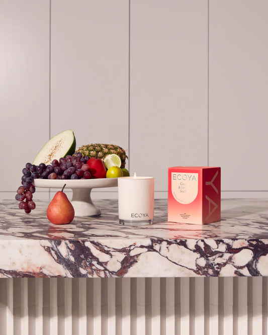 An ECOYA Guava & Lychee Sorbet scented candle with its lid off next to its packaging box.