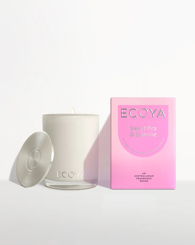Candle next to its packaging box labeled "ECOYA Sweet Pea & Jasmine" with a lit wick and open lid.