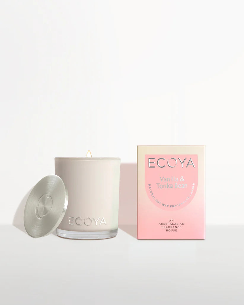 A scented candle with lid off next to its packaging box that reads ECOYA Vanilla & Tonka Bean.