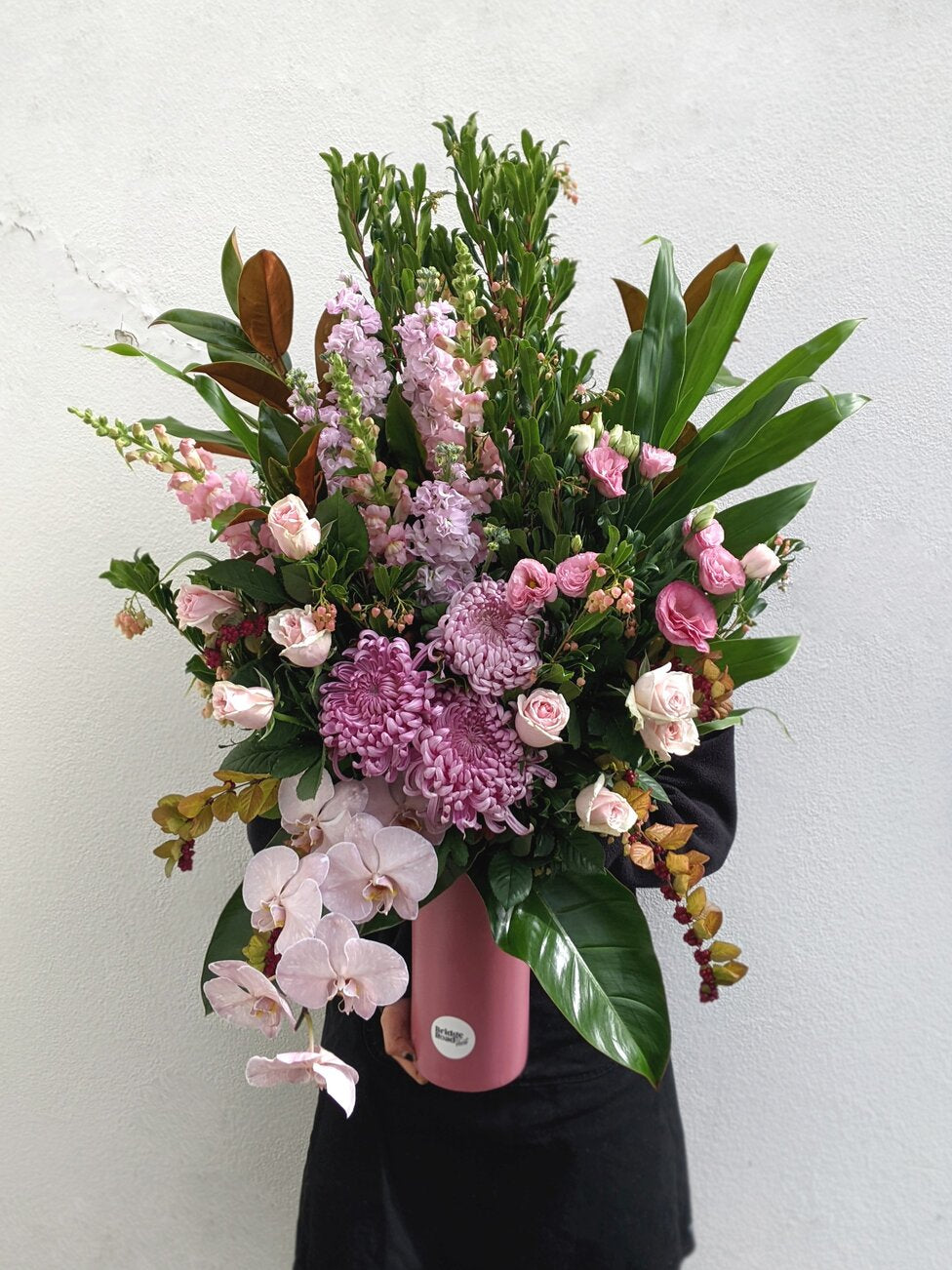 A beautifully arranged pink vase showcasing a variety of colorful flowers.