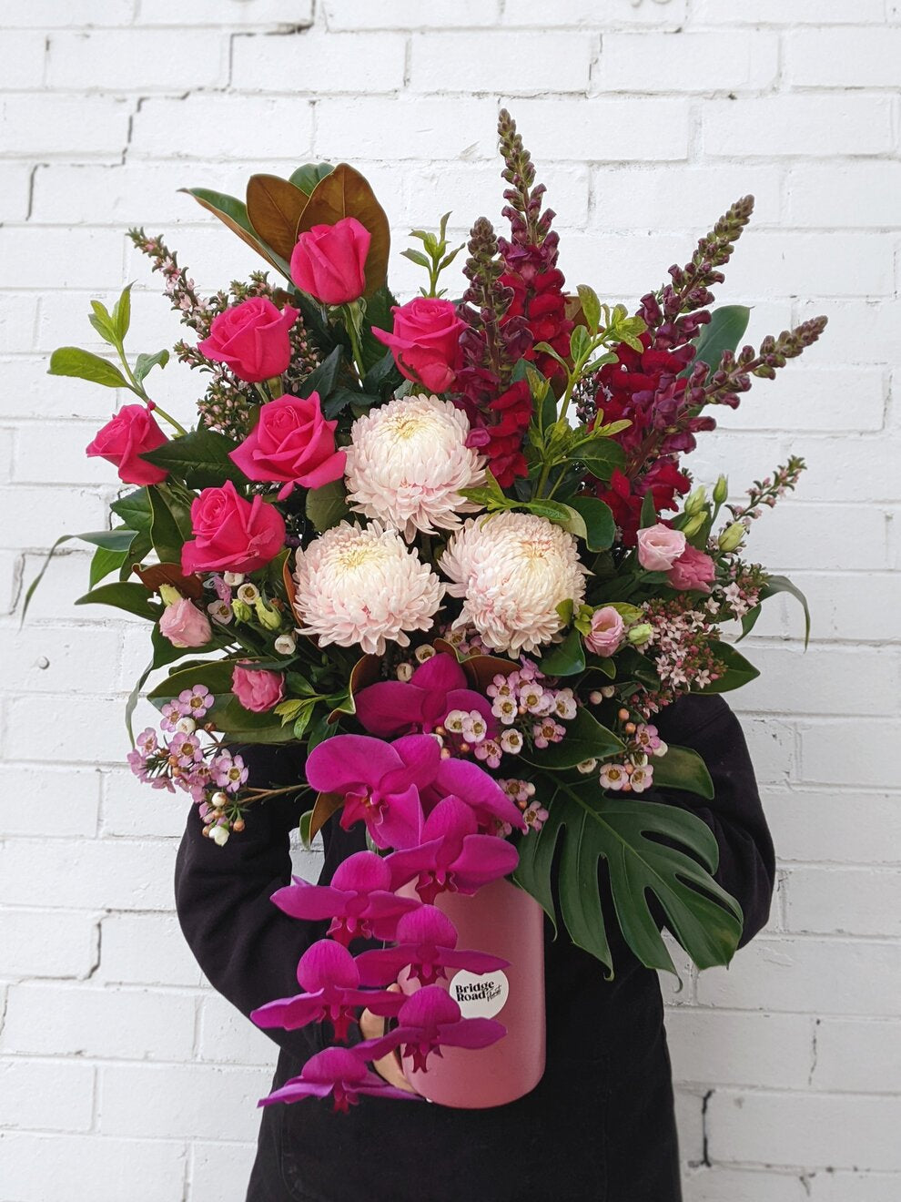 Woman gracefully holds a beautiful arrangement of pink and white flowers, showcasing nature's elegance and charm.
