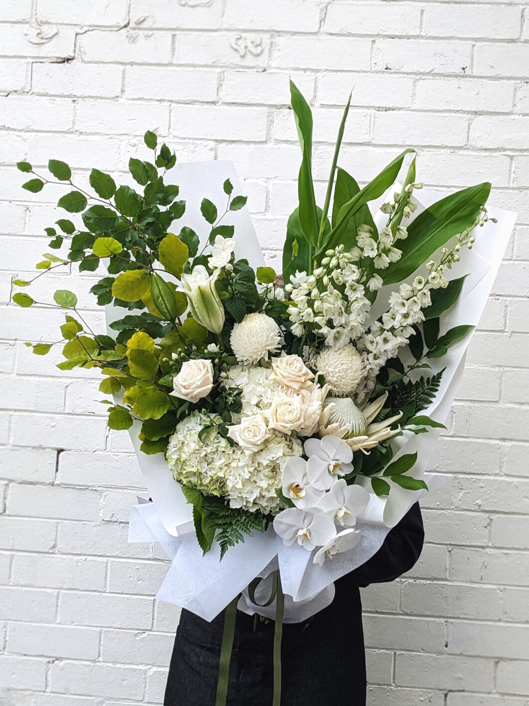 Woman presents a bouquet of white flowers, symbolizing purity and elegance in her poised demeanor.