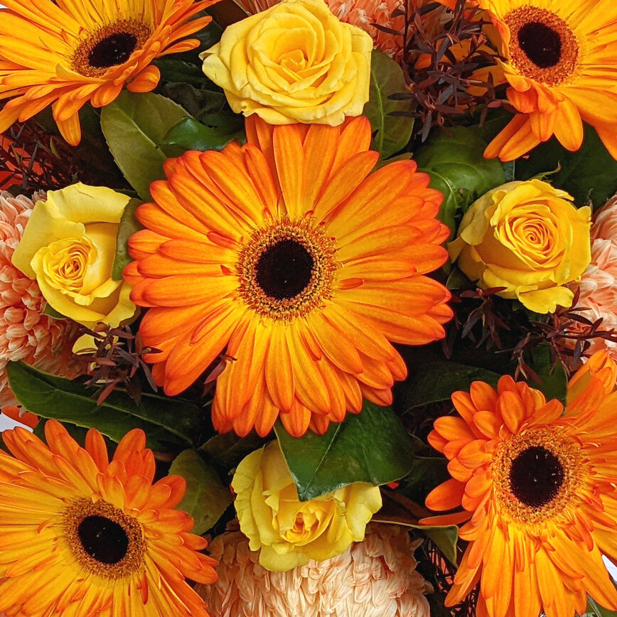 A vibrant bouquet of orange gerberas and yellow roses.