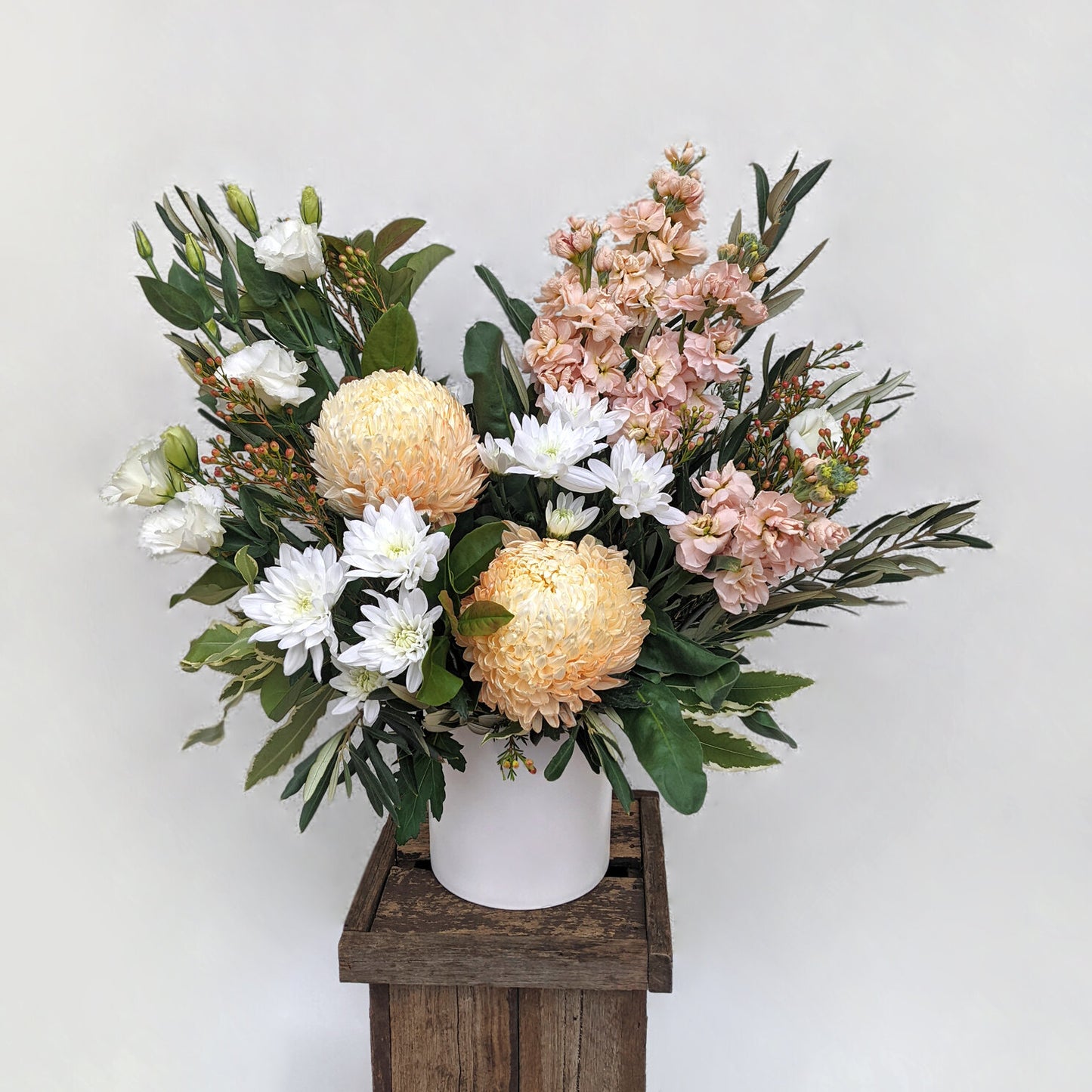 Elegant flower arrangement featuring pink and white blooms, artfully presented in a charming wooden box.