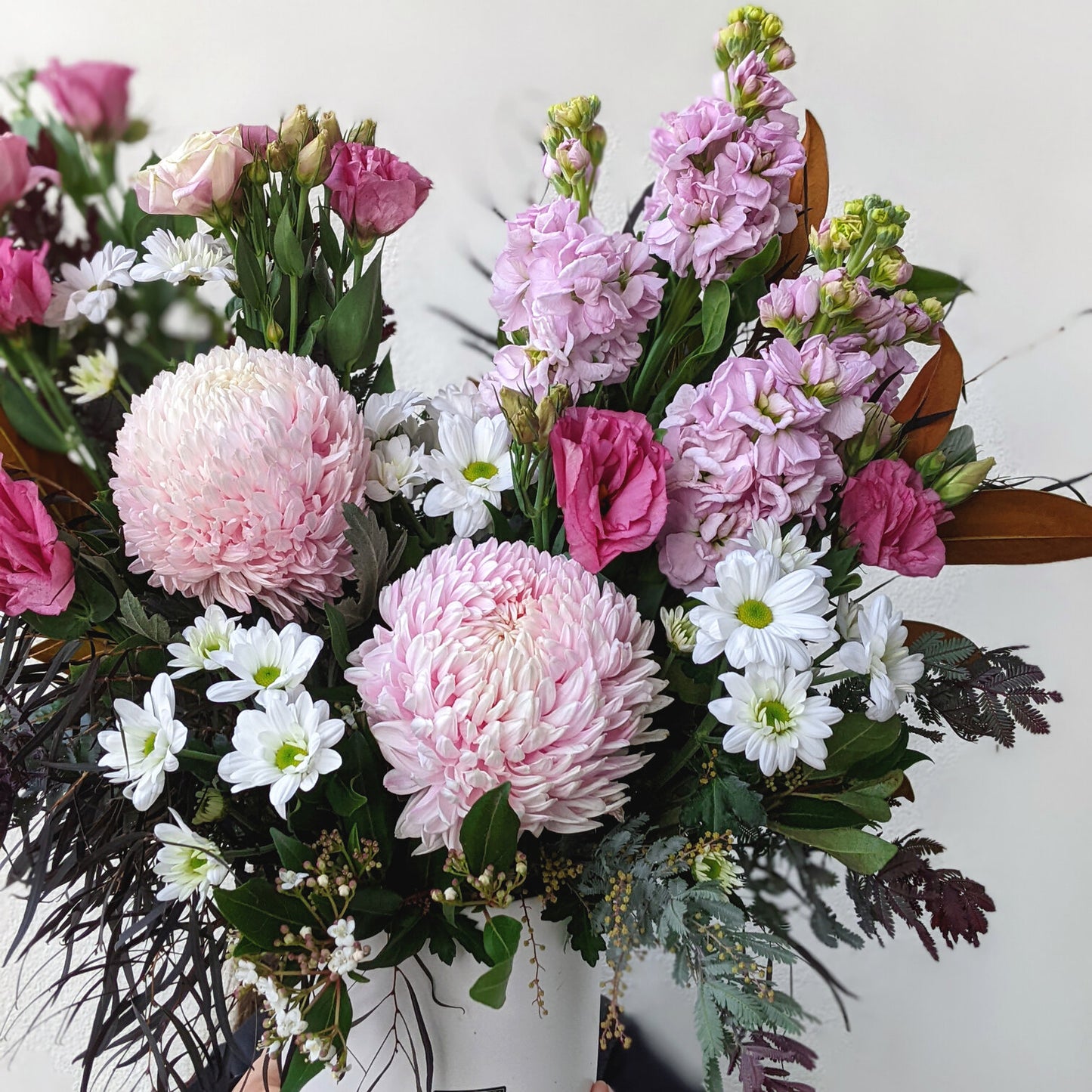 Elegant flower arrangement featuring pink and white blooms, artfully presented in a charming wooden box.