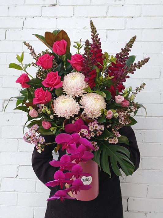 Woman gracefully holds a beautiful arrangement of pink and white flowers, showcasing nature's elegance and charm.